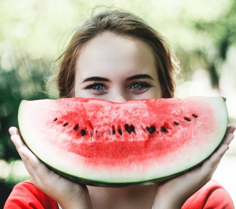 woman holding sliced watermelon