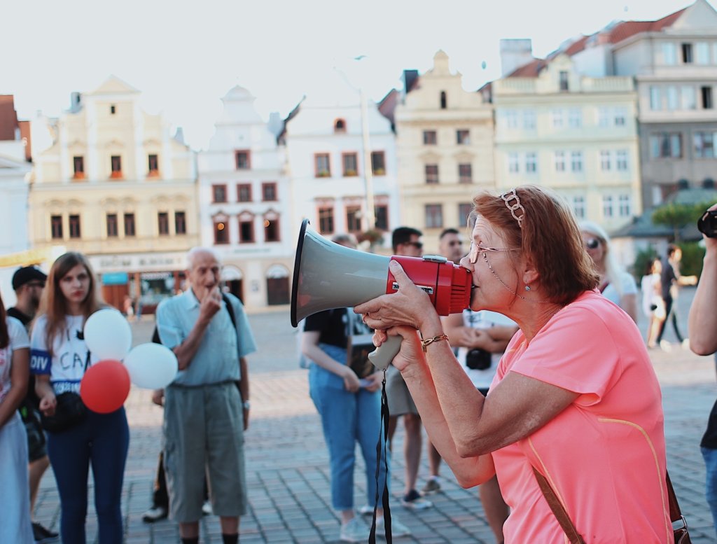 woman in pink shirt kissing man in black shirt during daytime